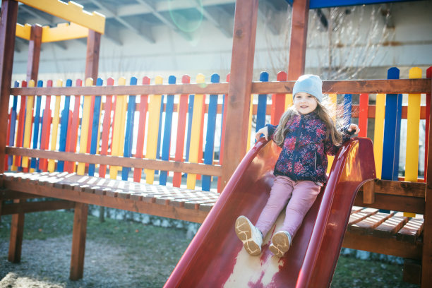 4岁的女孩在公园里玩滑梯图片下载