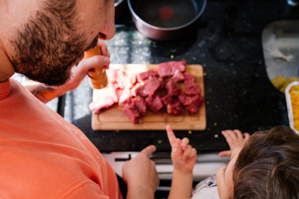 父亲和儿子正在煮肉的俯视图图片下载