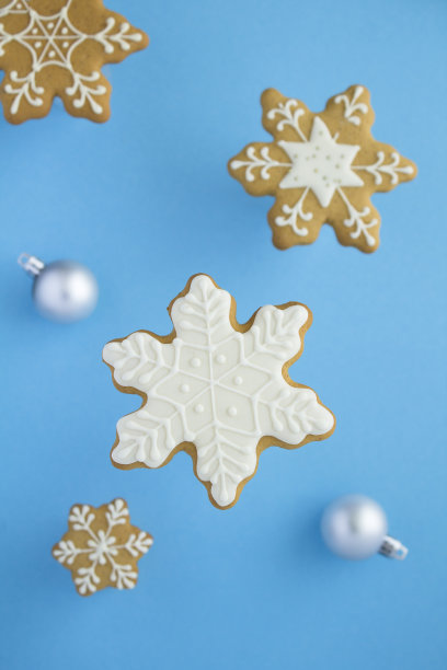 蓝色背景上的圣诞雪花形状的姜饼。前视图。图片下载