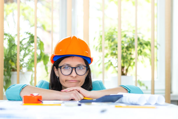 女工程师戴着橙色头盔的照片。图片下载