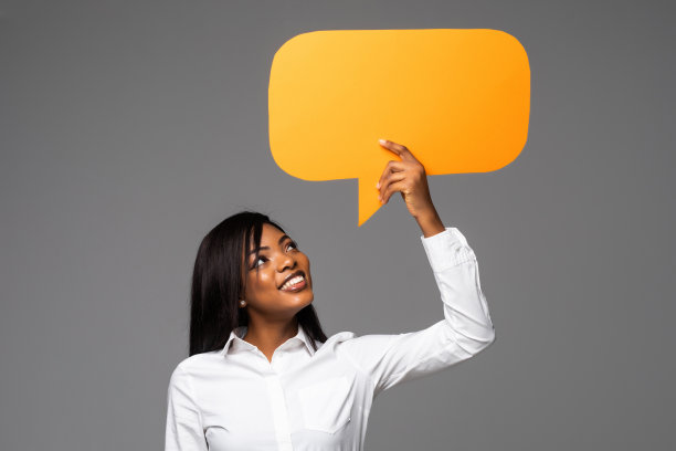 快乐的年轻非洲商人妇女的肖像持有空洞的讲话泡沫孤立在灰色的背景图片下载