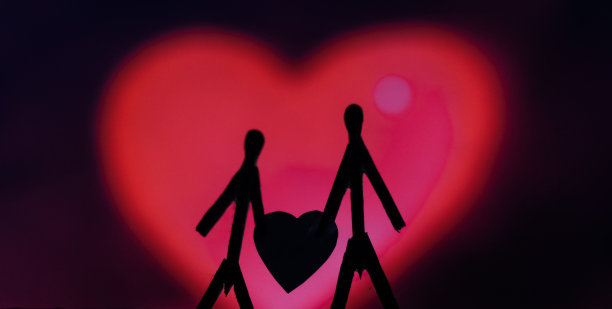 爱的夫妻用火柴棍的概念。男性和女性靠在一起，背景是美丽的心形。火柴艺术摄影用火柴棒创造了这个人物。图片下载