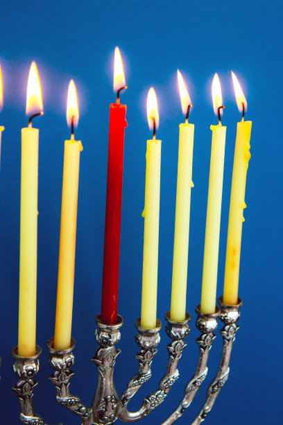 明亮的蓝色背景上，银色光明节烛台上有燃烧的蜡烛图片下载