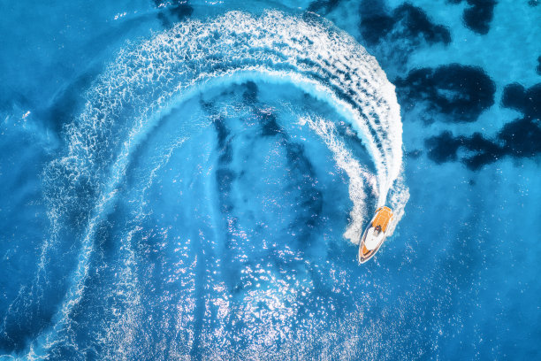 航拍的快艇在清澈的蓝色的水在晴朗的一天在夏天。俯视图从无人机快速漂浮的游艇在地中海。在土耳其的Oludeniz旅行。热带景观与摩托艇图片下载