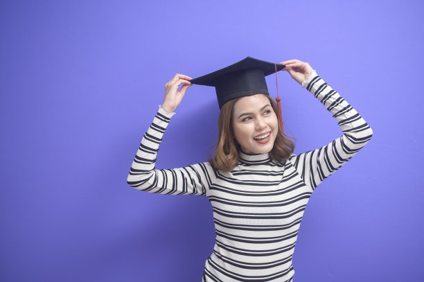 蓝色背景下的年轻女子毕业画像图片下载