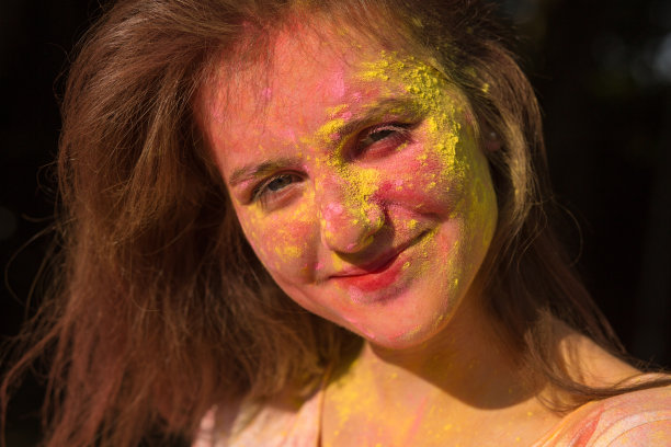 积极的黑发女孩覆盖着黄色和粉红色的干油漆在胡里节图片下载
