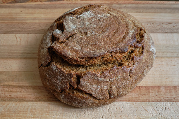 面包。面包酵母的国家。在木砧板上放上新鲜出炉的脆皮。新鲜烘焙的黑麦面包。图片下载