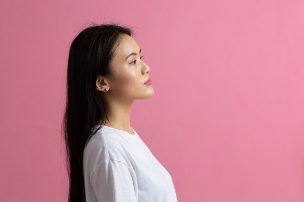 粉色背景上的亚洲女人的肖像图片下载