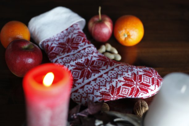 圣诞老人的圣诞袜上有降临节花环、蜡烛、苹果、果仁。图片下载