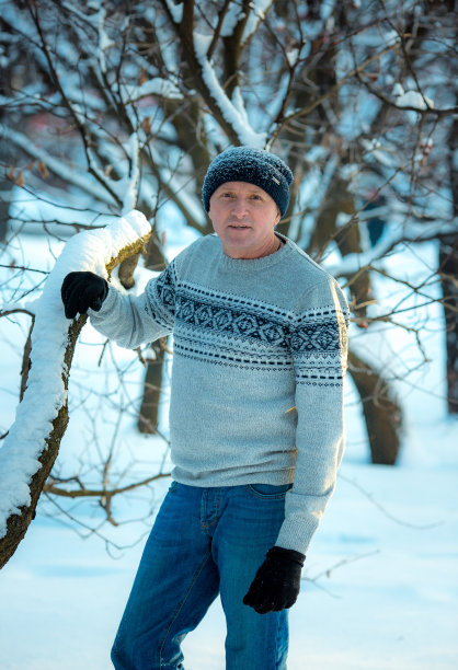一个男人在一个下雪的日子里在森林里的肖像。那个穿冬季运动装的家伙。图片下载