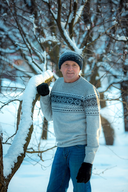 一个男人在一个下雪的日子里在森林里的肖像。那个穿冬季运动装的家伙。图片下载