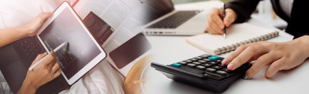 年轻、快乐、快乐、可爱、美丽的女商人坐在办公室的室内，使用笔记本电脑，戴着耳机听音乐。图片下载