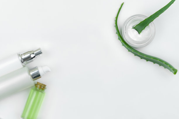 护理霜与芦荟叶在白色的背景。前视图。皮肤护理的概念图片下载