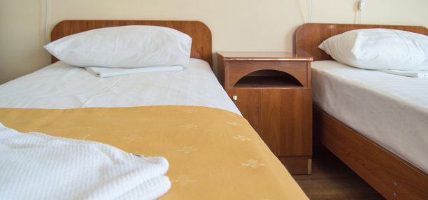 酒店客房有两张空单人床和床头柜，是酒店经营的概念图片下载