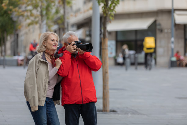 一对老年游客在享受假期的同时，探索城市，用相机捕捉瞬间。图片下载