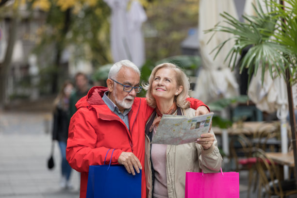 一对老年夫妇正在享受假期，并利用旅游地图探索城市。图片下载