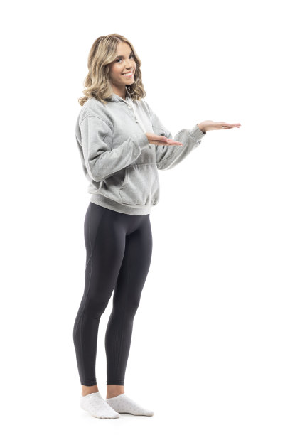 可爱快乐的年轻女子在家中，穿着舒适的休闲服装，展示和呈现着空旷的空间图片下载