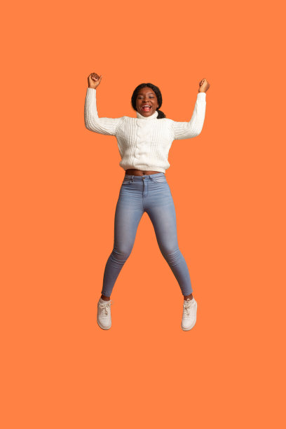 大赢。激动的非洲裔美国妇女在空中跳着庆祝成功图片下载