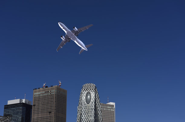 低角度的飞机飞过摩天大楼与复制空间。图片下载
