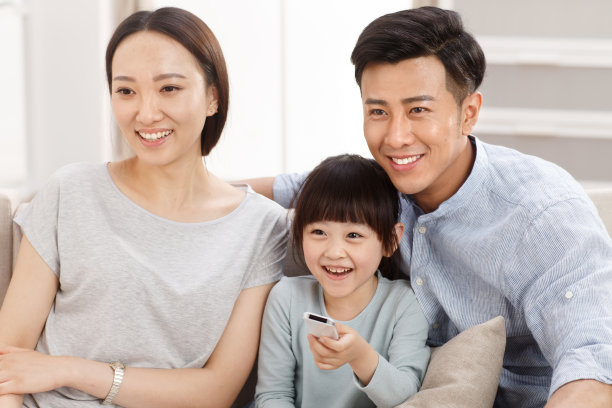 幸福的一家三口在客厅看电视图片下载