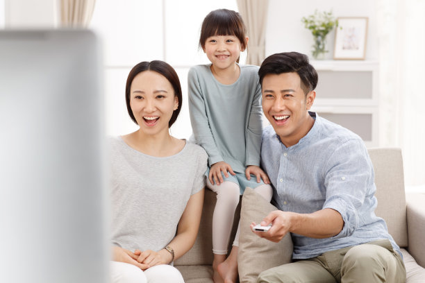 幸福的一家三口在客厅看电视图片下载