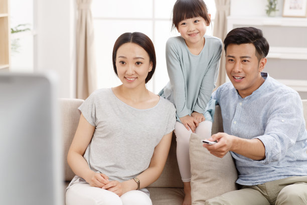 幸福的一家三口在客厅看电视图片下载