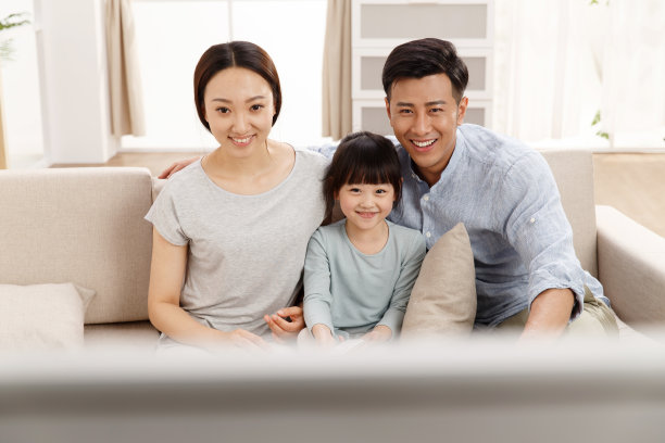 幸福的一家三口在客厅看电视图片下载
