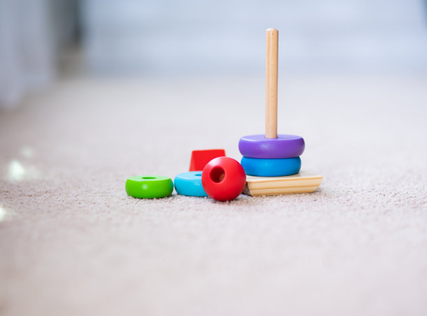 为蹒跚学步的幼儿堆叠木制玩具环图片下载