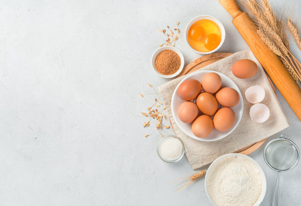 鸡蛋、面粉、糖、擀面杖和灰色背景的小麦。原料烘烤图片下载
