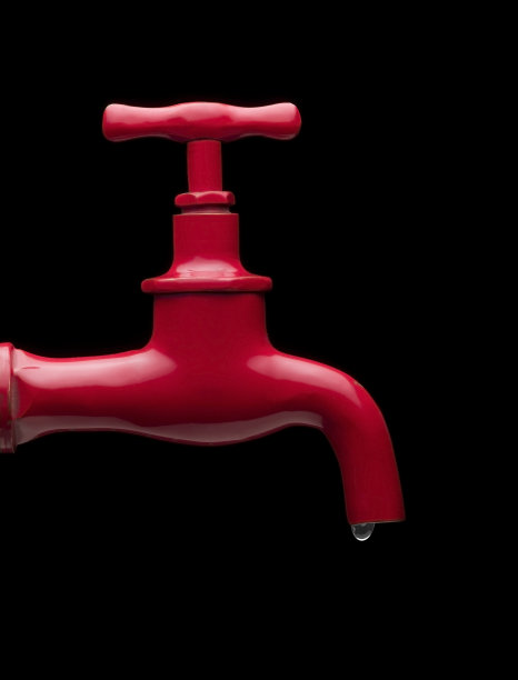 红色水龙头，带有水滴，黑色背景图片下载