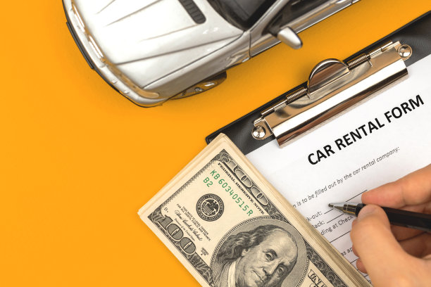 填写租车表格的人。写字板放在办公桌上，上面放着美元和汽车玩具。顶视图的照片图片下载