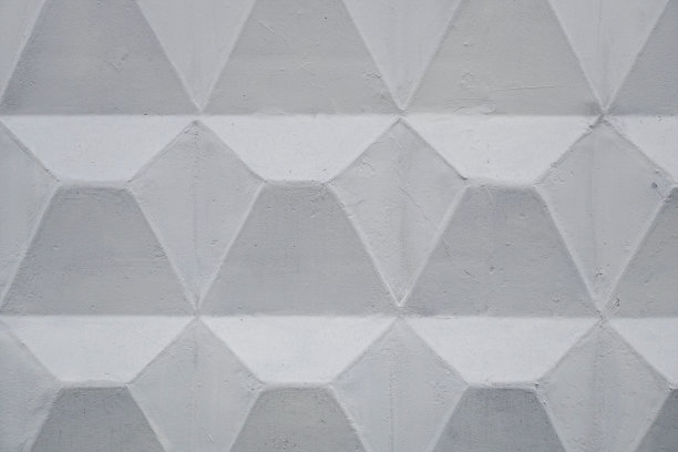 浮雕背景纹理的旧灰色混凝土栅栏与方形图案。城市的抽象背景。图片下载