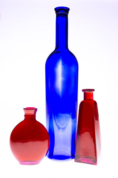 白色背景上的洋红色和蓝色瓶子。与独特的颜色和效果创造的光通过他们图片下载