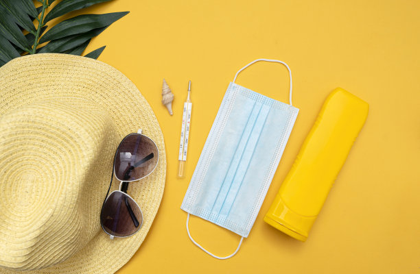 一套用于流感期间的度假用品，帽子，温度计，医用口罩，黄色背景的眼镜。图片下载