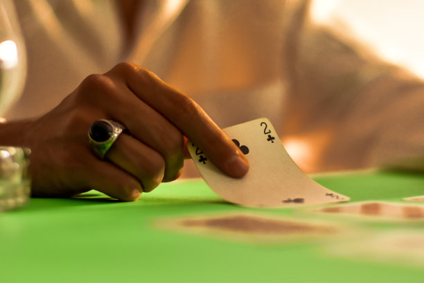 一张年轻赌徒玩扑克的照片，仔细观察他的下一步行动图片下载