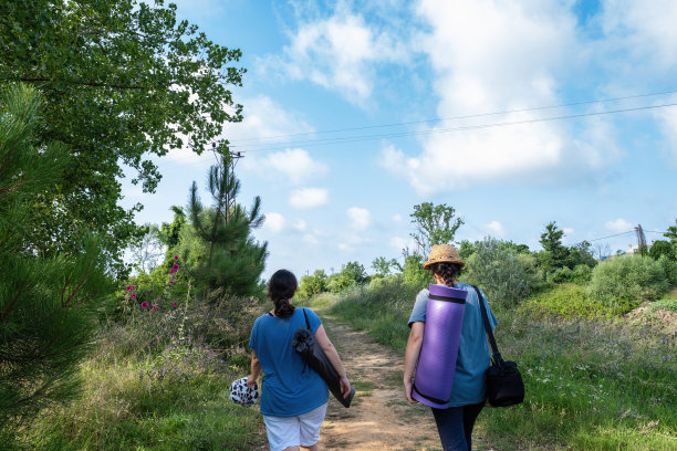 两个年轻的女游客带着水桶遮阳帽背着背包旅行图片下载