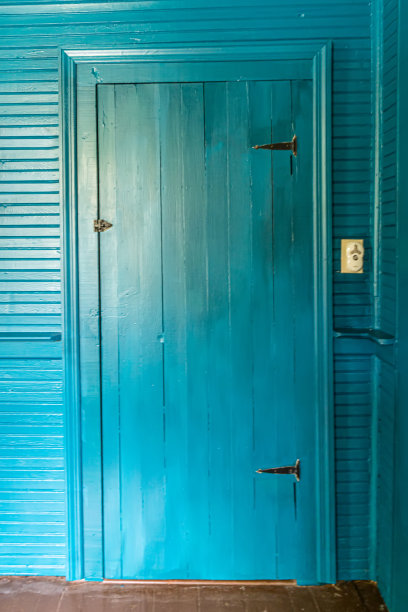 绿松石室内衣柜门与相同的颜色油漆墙壁和装饰在老房子与正宗的原始床头板。图片下载