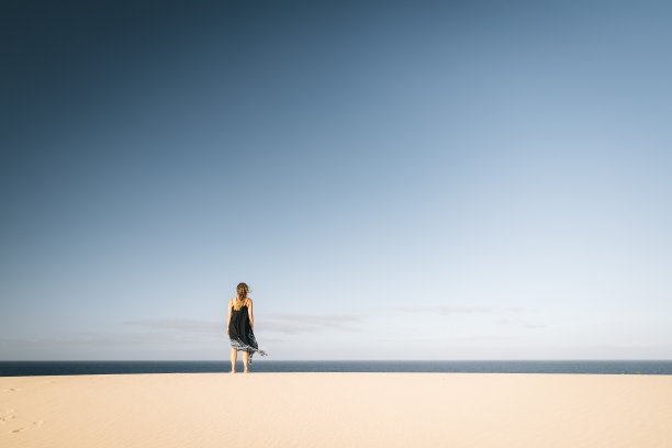 在加纳利群岛的兰萨罗特，一名年轻女子在海岸沙丘上休息图片下载