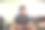 一个十几岁的男孩戴着耳机在玩电子游戏。他穿着灰色的t恤和短裤。图片下载