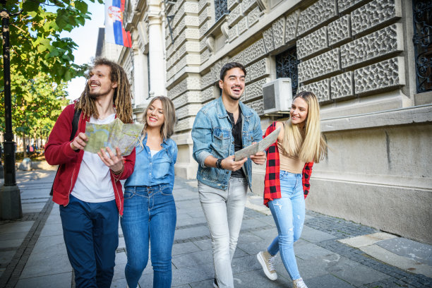 一群快乐的旅行者正在城市中行走，并使用地图探索风景。图片下载