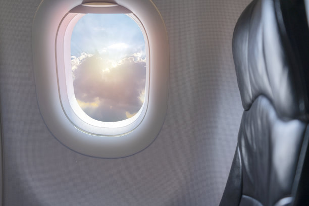 在阳光明媚的日子里，乘客座位上的白云在高空洒满阳光。图片下载
