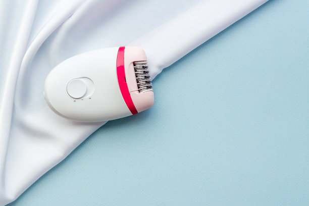 柔软丝绸上的白色脱毛毛。脱毛和脱毛的概念图片下载