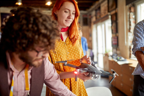 办公室里一群富有创造力的年轻同事正在计划如何在他们正在做的项目中使用无人机图片下载