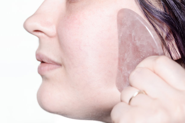 女士用石英刮刀近距离按摩脸颊图片下载