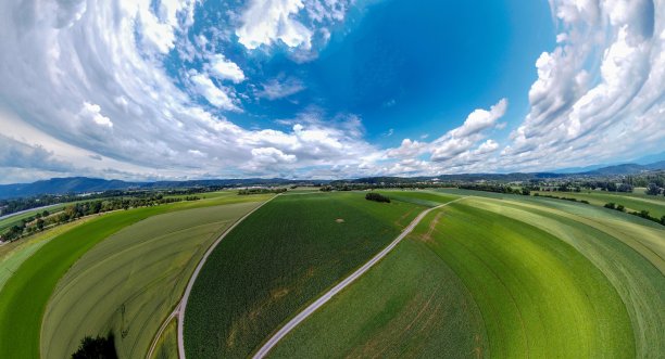 抽象的全景鸟瞰图在森林和田野与奇异美丽的云和弯曲的空间像一个小行星图片下载