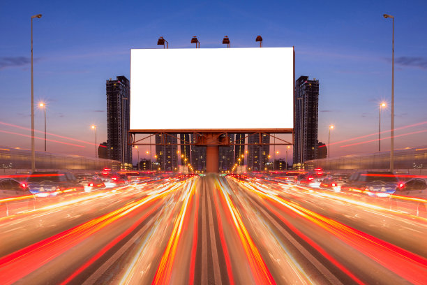 在夜晚，在街道和城市的线路灯光的空白广告牌-可以展示或蒙太奇产品或业务的广告。图片下载