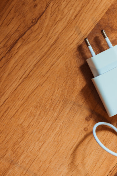 手机充电器放在一个木制的背景上。图片下载