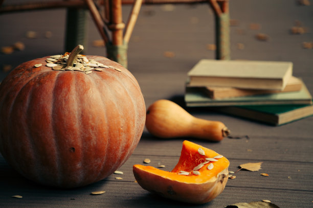 浪漫的秋天。南瓜和成堆的书在地板上。图片下载