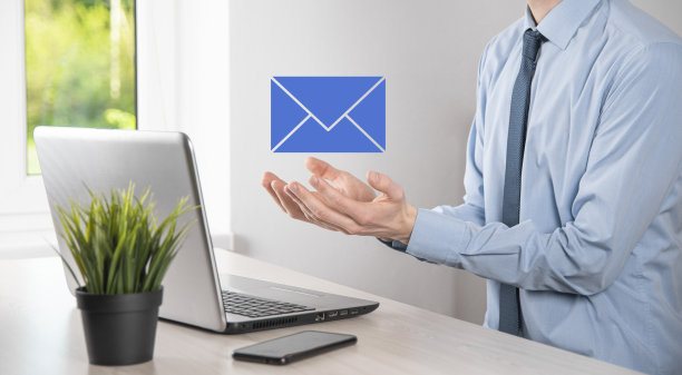 商人手握电子邮件图标，联系我们的时事通讯电子邮件和保护您的个人信息从垃圾邮件。客户服务呼叫中心联系我们的概念图片下载