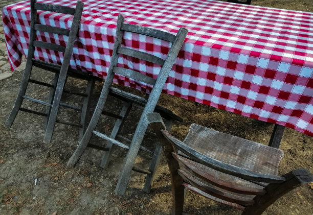 三张老式木制椅子和一张有红色格子桌布的桌子图片下载